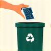 A hand placing electronics into a recycling bin